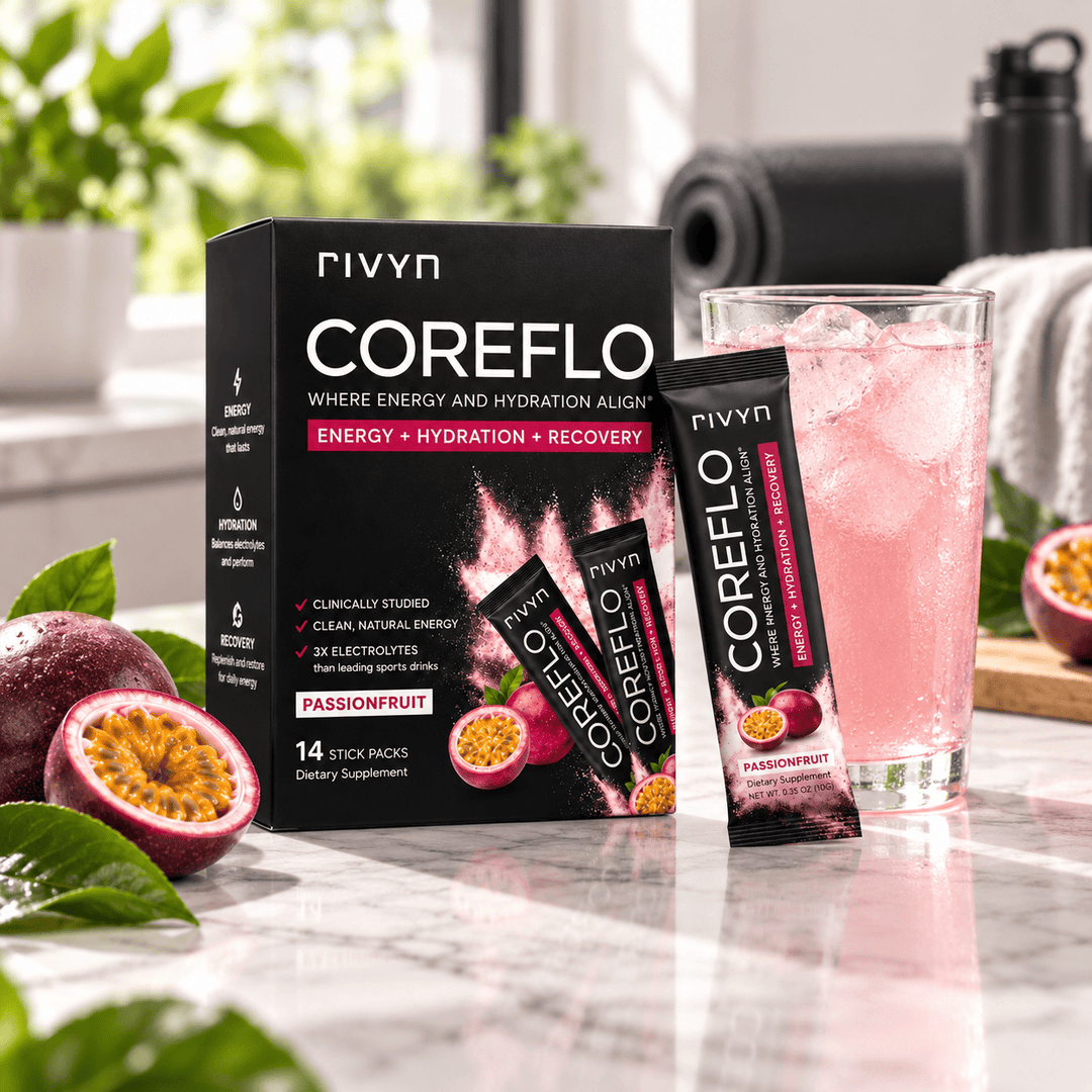 A box of rivyn CoreFlo Passionfruit dietary supplement alongside a glass of pink iced drink, with passionfruit halves and green leaves on a marble countertop.